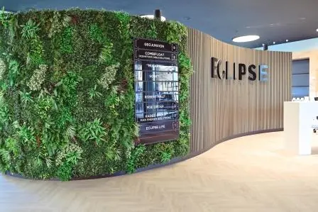 Moderne ontvangsthal van het Eclipse-gebouw aan het Rivium Quadrant met een groene plantenwand en bedrijfsnamenbord.